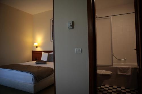 蒂米什瓦拉萨沃伊酒店的一间卧室配有一张床,浴室设有浴缸