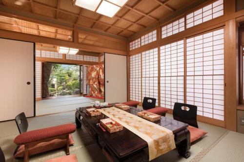 京都Kyo-machiya Stay WAKA Fushimiinari的配有桌椅和窗户的大房间