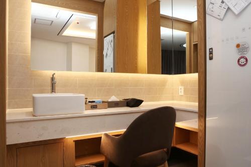 光州Hotel Artheim的一间带水槽和镜子的浴室