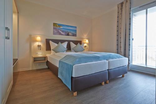 伯尔格伦德-雷特维施Sunny Suite 14 - charmant und elegant mit Pool und Saunabereich的一间卧室设有一张大床和一个大窗户