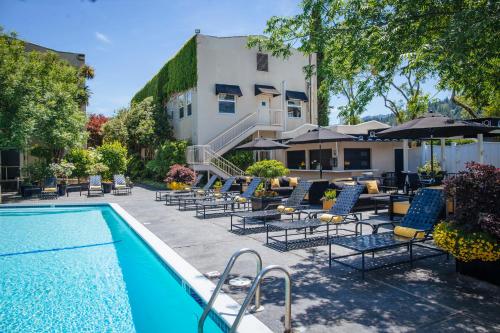 卡利斯托加山景酒店及Spa中心的一座带椅子和遮阳伞的游泳池位于一座建筑旁边