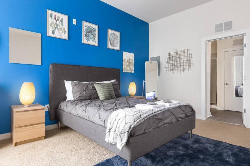 夏洛特Trifecta Ace Location Pool & Gym Superhost的蓝色的卧室,配有床和蓝色的墙壁