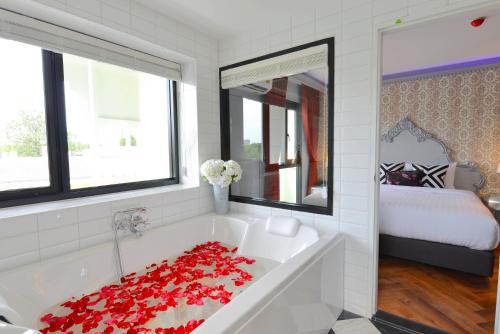 曼谷Villa De Khaosan by Chillax的白色的浴室设有红色玫瑰花浴缸和