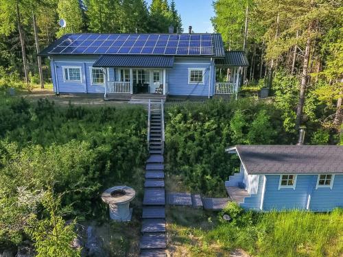 Vuoriniemi诺尔帕度假屋的蓝色房子的空中景色,上面有太阳能电池板