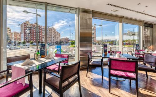 瓦伦西亚Senator Parque Central的一间设有桌椅的餐厅,享有城市美景