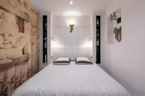 梅斯UnSejourAmetz-fr Meublés Ossons du T2 au T4 avec parking,的卧室配有一张带两个枕头的大白色床