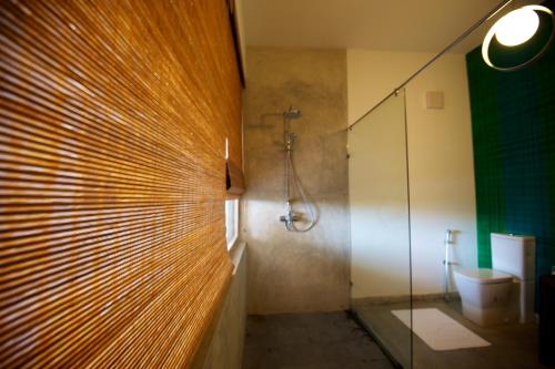 希克杜沃Roman Beach Hotel的一间带玻璃淋浴和卫生间的浴室