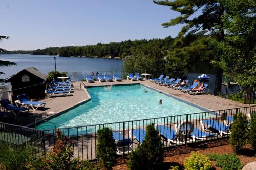 MacTier洛基洪峰高尔夫度假酒店的一个带椅子和湖泊的大型游泳池