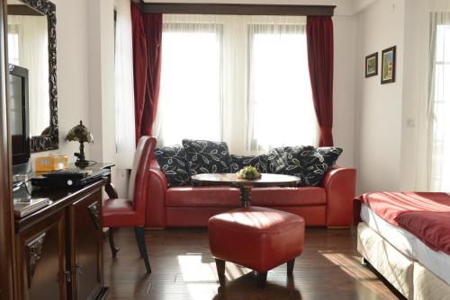 奥赫里德玛尔斯维特卡尔蒙特别墅酒庄酒店的客厅配有红色的沙发和桌子