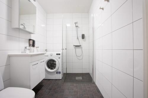 林雪平林雪平体育场直接公寓的白色的浴室内配有洗衣机。