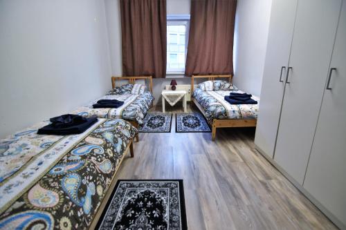 科隆Apartment Köln-Mülheim的带三张床和一张桌子的房间