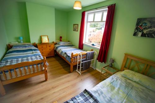 BargrennanCulsharg Cottage的一间卧室设有三张床和窗户。