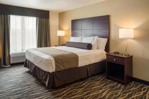 阿什兰Cobblestone Inn and Suites - Ashland的酒店客房设有一张大床和两盏灯。