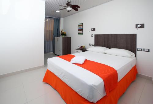 圣何塞Hotel Milan Costa Rica的一间卧室配有一张带橙色毯子的大床