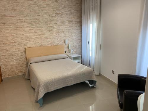 瓦尔德莫罗塞万堤斯旅馆的一间卧室设有一张床和砖墙