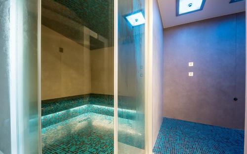 Unterbäch瓦里瑟霍夫体育酒店的浴室内设有一个游泳池及玻璃淋浴间