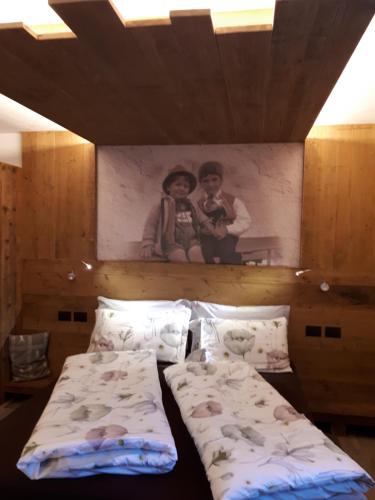 博萨迪法萨Majon de la nona的卧室配有两张床,墙上挂着一幅画