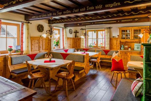恩斯塔尔豪斯林哈特霍夫酒店的餐厅设有木桌、椅子和窗户。