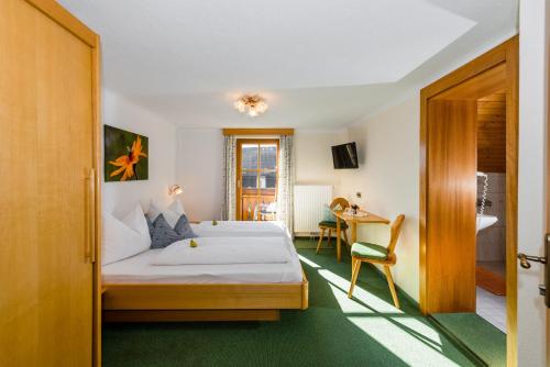 恩斯塔尔豪斯林哈特霍夫酒店的配有一张床和一张书桌的酒店客房