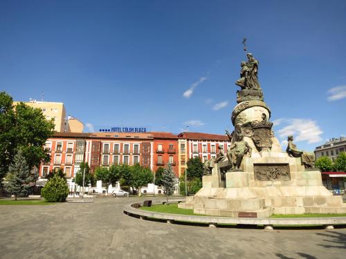 巴利亚多利德Hotel Colón Plaza的建筑前方方方形中的雕像