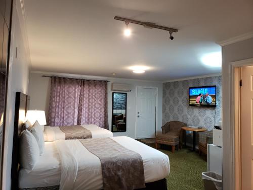 康沃尔Regency Inn & Suites的酒店客房设有两张床和一台平面电视。