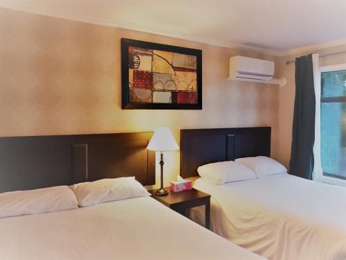 鲍威尔里弗威斯幽中心汽车旅馆的酒店客房设有两张床,墙上挂着一张照片。