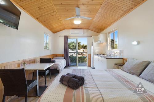 鲍恩海港之灯旅游假日公园的一间卧室配有一张床,厨房配有桌子