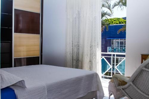 弗洛里亚诺波利斯Apto a 70 metros da praia, Piscina, 03 Ar Condicionados, Vaga de Garagem的一间卧室设有一张床和一个窗口