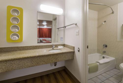 康科德康科德6号汽车旅馆的一间带水槽、浴缸和镜子的浴室