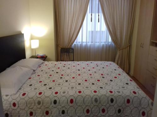 基多Cerca a Mitad del Mundo的一间卧室配有一张红色鲜花的大床