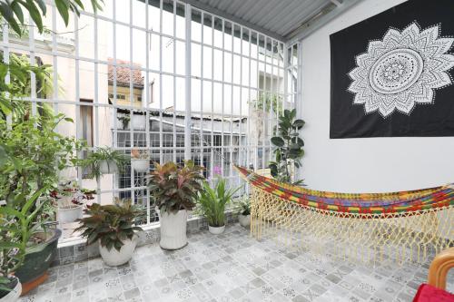 胡志明市西贡四月旅馆的一间种植了盆栽植物并配有吊床的房间
