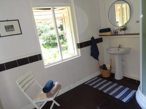马特莱斯特拉塞斯茶园简易别墅旅馆的一间带椅子、水槽和窗户的浴室