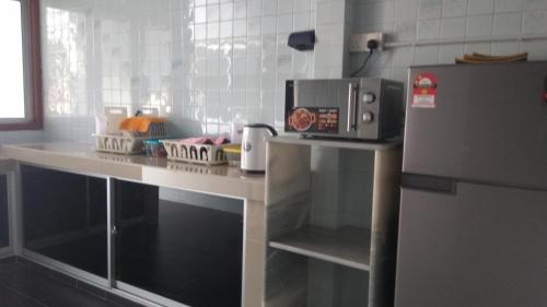 务边Gopeng TownHouse的厨房配有微波炉和冰箱。