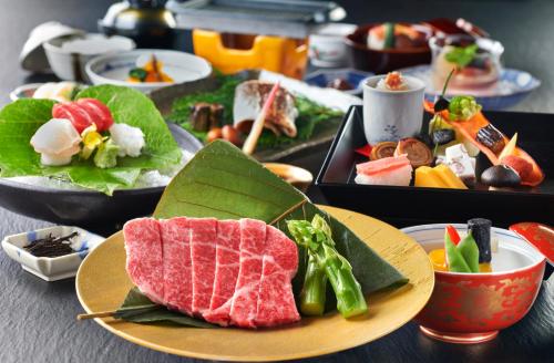 高山本阵平野屋花兆庵酒店的餐桌上放有肉和蔬菜的盘子