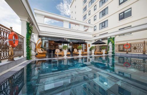 岘港岘港莫纳科酒店的一座建筑物中央的游泳池