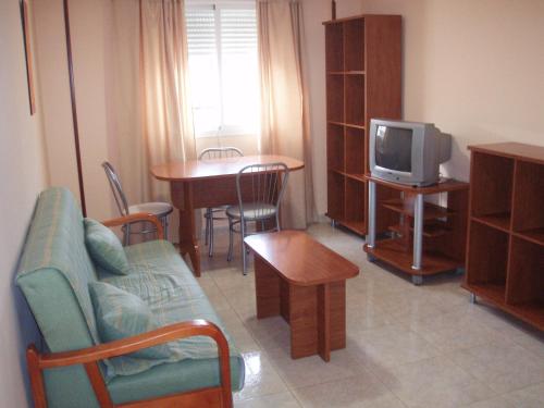 奥卡尼亚赫尔马诺斯公寓酒店的带沙发、电视和桌子的客厅