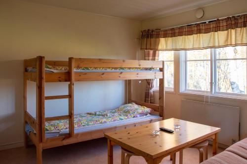 艾尔夫达伦Älvdalens Camping的客房内的双层床和桌子