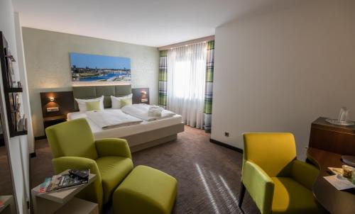 多特蒙德德瑞斯环形酒店的酒店客房,配有一张床和两把椅子