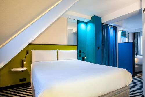 巴黎霹雳姆酒店的卧室配有白色的床和蓝色的门