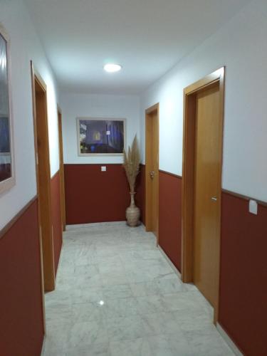 RocianaHostal Monteluna的走廊上设有两扇门和花瓶