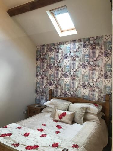 巴茅思美丽威尔士度假屋的一间卧室,床上有红色的鲜花