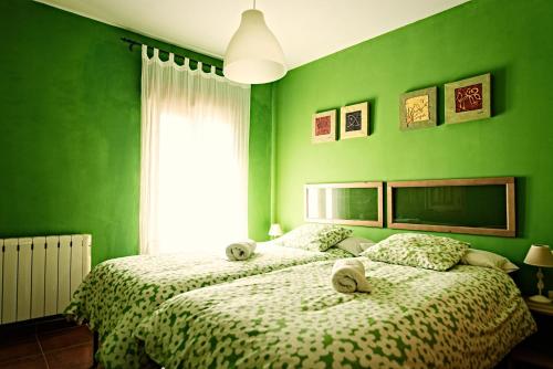 锡古恩萨Casa La Alegria De La Alcarria II的绿色卧室设有两张床和窗户