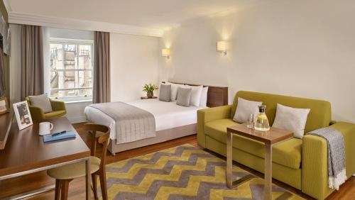 伦敦伦敦南肯辛顿馨乐庭馨乐庭服务公寓的酒店客房配有床、沙发和桌子。