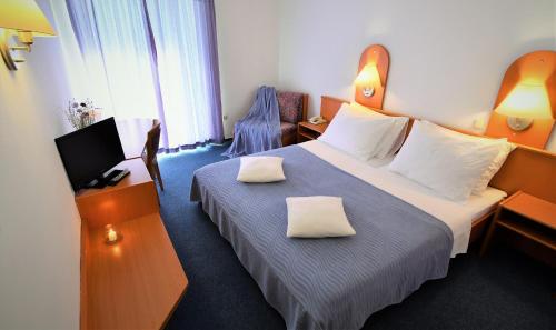 锡尼Hotel Alkar的酒店的客房 - 带两张枕头的床