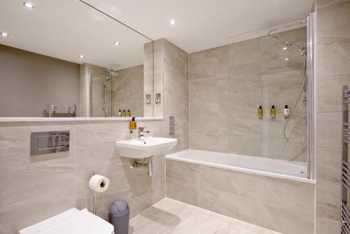 爱丁堡Destiny Scotland New Town Apartments的一间带水槽、浴缸和淋浴的浴室