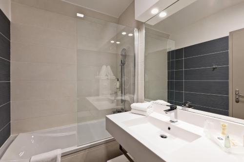 里昂贝斯特韦斯特里昂克雷吉酒店的一间带水槽、浴缸和镜子的浴室