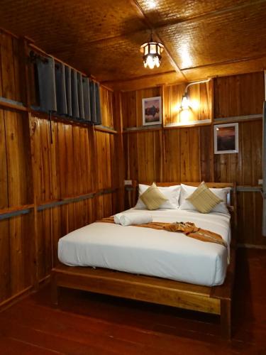高兰Lanta Para hut的木制客房内的一间卧室,配有一张床