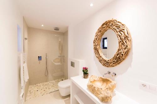 埃斯卡洛Sa Cala Suites的浴室设有卫生间和墙上的镜子。