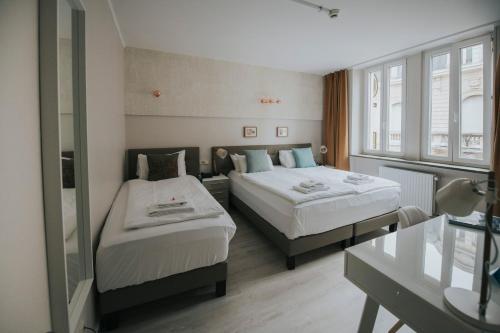 卢森堡乐夏特勒的酒店客房设有两张床和窗户。
