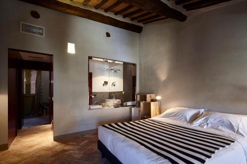 锡耶纳Palazzetto Rosso - Art Hotel的一间卧室配有一张大床和镜子